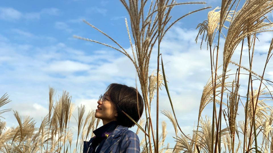 Joohee Seo standing among silver grass